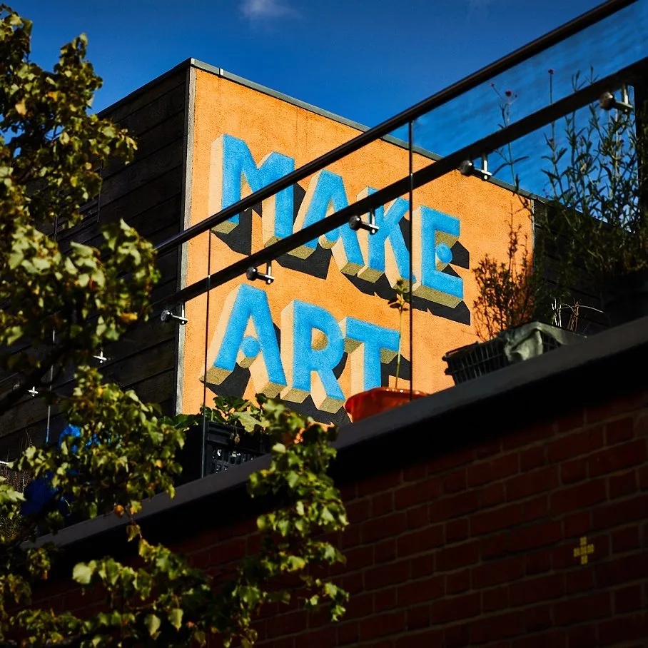 Detail of 'Make Art Now' mural on The Art House terrace taken from street level.