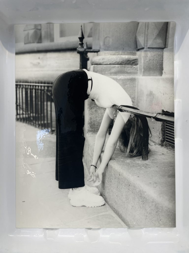 A black and white photograph of a woman bending over