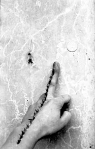 A black and white photograph of a hand with spikes along the finger by Lucy Marriott