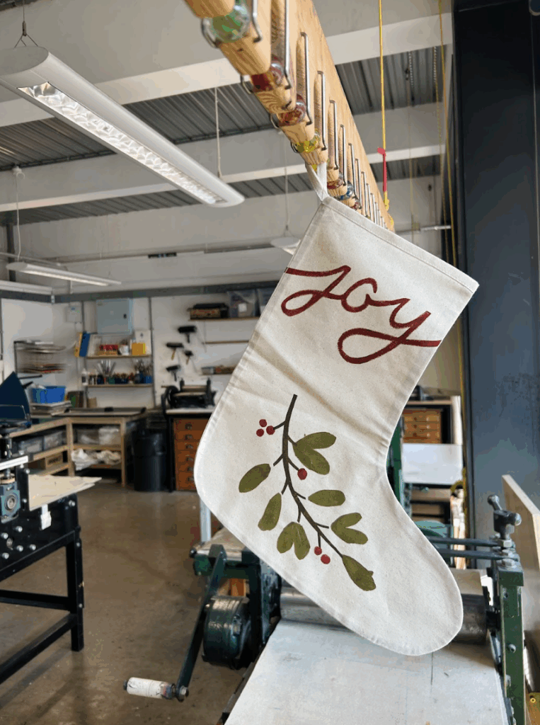 Screen Printed Christmas Stocking with a design of Mistletoe and text reading 'Joy'