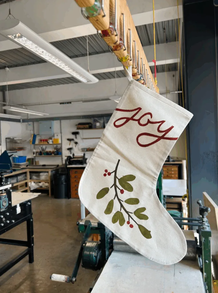 Screen Printed Christmas Stocking with a design of Mistletoe and text reading 'Joy'