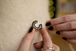 A Changemakers Badge being worn on a cream jumper.