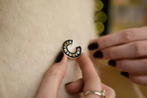 A Changemakers Badge being worn on a cream jumper.