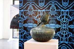 Blue intricate wall mural and ceramic pit inside the Hospital Rooms Exhibition.